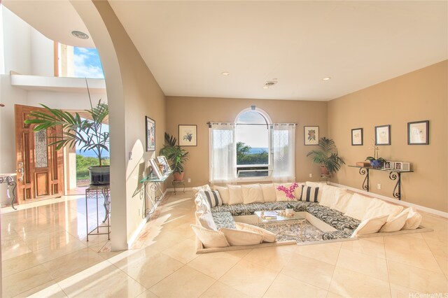living room with arched walkways, baseboards, tile patterned floors, and recessed lighting