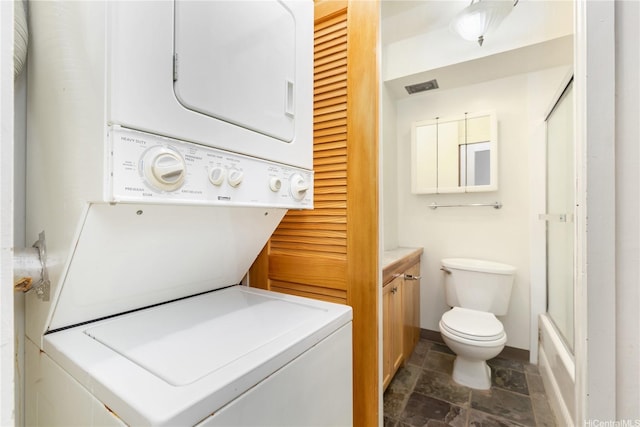 2345 Ala Wai Blvd Unit 1806, Honolulu, HI 96815 - clothes washing area featuring stone tile flooring, estacked washer and dryer, and baseboards