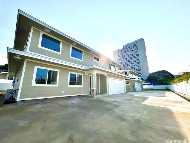 back of property featuring fence, driveway, and an attached garage