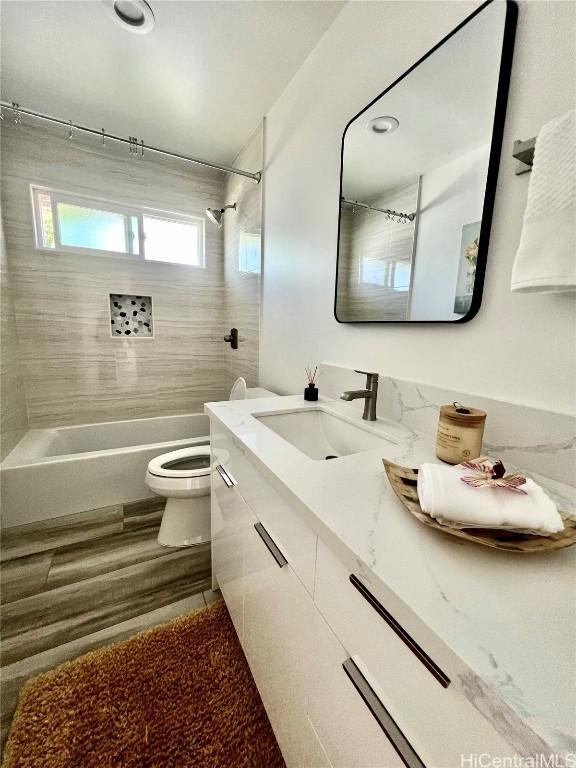 full bathroom with toilet, vanity,  shower combination, and wood finished floors