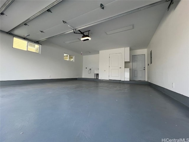 garage featuring baseboards, a sink, and a garage door opener