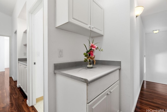 94-835 Lumiauau St Unit K105, Waipahu, HI 96797 - kitchen with dark wood-style flooring, white cabinetry, and baseboards