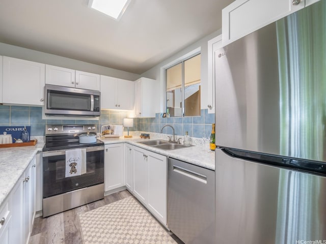 46-109 Konohiki St Unit 3913, Kaneohe, HI 96744 - kitchen featuring stainless steel appliances, a sink, light wood-style floors, and white cabinetry