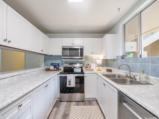 46-109 Konohiki St Unit 3913, Kaneohe, HI 96744 - kitchen featuring appliances with stainless steel finishes, a sink, light wood-style flooring, and light countertops