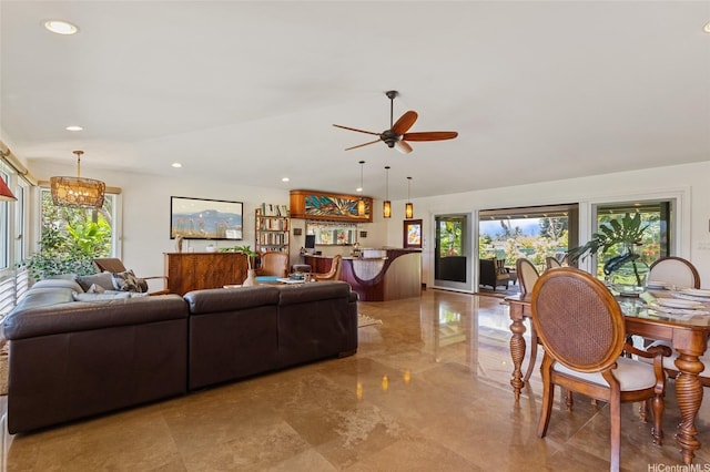 living area with ceiling fan with notable chandelier, recessed lighting, lofted ceiling, and marble finish floor
