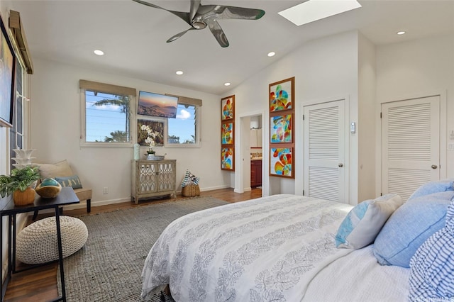 bedroom with vaulted ceiling with skylight, baseboards, recessed lighting, and wood finished floors