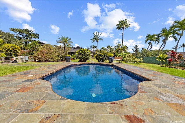 outdoor pool with a lawn, fence, and a patio