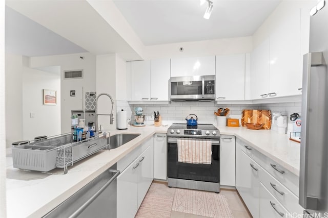 415 S St Unit 302, Honolulu, HI 96813 - kitchen with backsplash, white cabinetry, appliances with stainless steel finishes, and visible vents