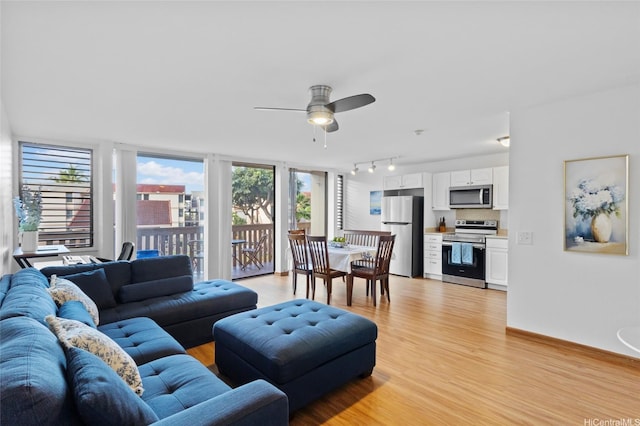 living room featuring light wood finished floors, ceiling fan, and track lighting