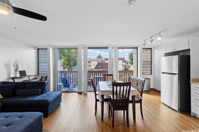dining area featuring ceiling fan, light wood-style flooring, and rail lighting