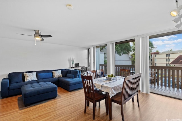 dining space with a ceiling fan and wood finished floors