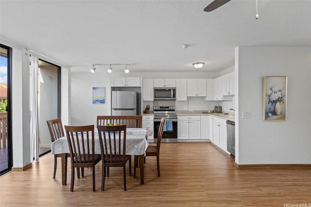 kitchen with stainless steel appliances, light wood-type flooring, ceiling fan, white cabinetry, and light countertops