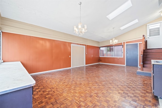 84-731 Upena St, Waianae, HI 96792 - unfurnished dining area featuring a chandelier, vaulted ceiling, a skylight, wood walls, and baseboards