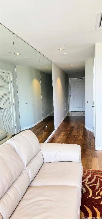 unfurnished bedroom featuring visible vents, a closet, baseboards, and wood finished floors