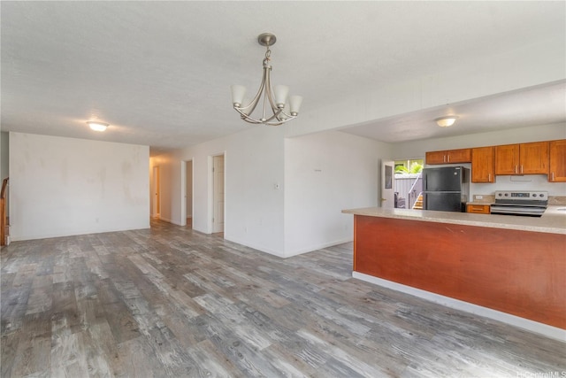 47-325 Ahuimanu Rd, Kaneohe, HI 96744 - kitchen with stainless steel electric range oven, brown cabinets, freestanding refrigerator, open floor plan, and wood finished floors