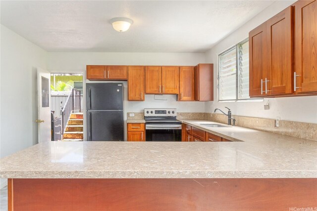 47-325 Ahuimanu Rd, Kaneohe, HI 96744 - kitchen featuring electric stove, freestanding refrigerator, brown cabinetry, a sink, and a peninsula