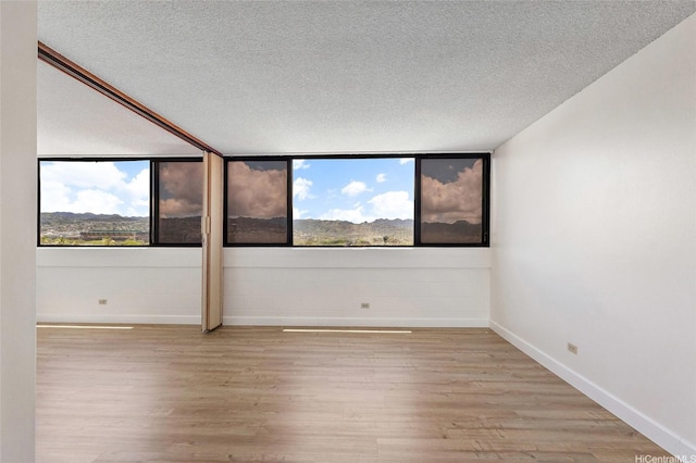 99-015 Kalaloa St Unit 803, Aiea, HI 96701 - spare room featuring baseboards, light wood-style flooring, and a textured ceiling