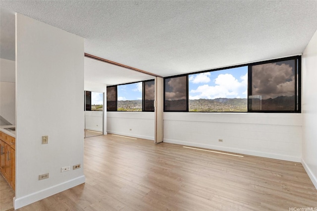 99-015 Kalaloa St Unit 803, Aiea, HI 96701 - unfurnished room featuring light wood finished floors, baseboards, and a textured ceiling