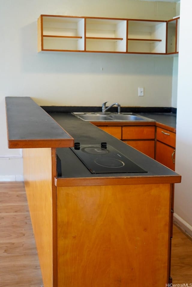 53-549 Kamehameha Hwy Unit 514, Hauula, HI 96717 - kitchen featuring open shelves, black electric stovetop, light wood-type flooring, and dark countertops