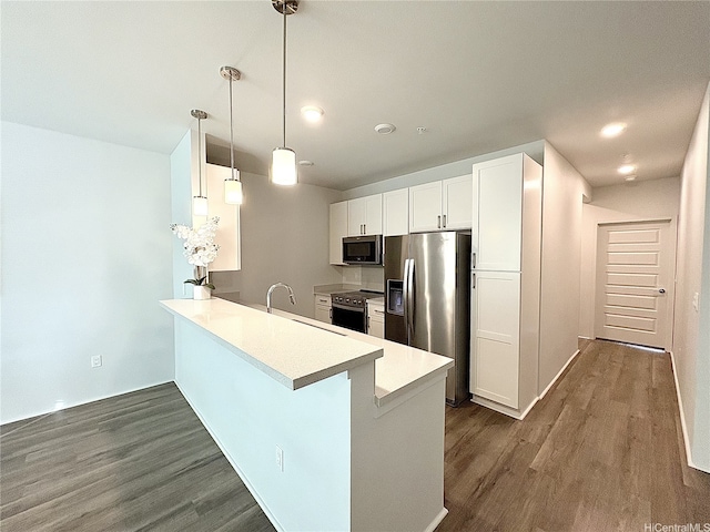 91-3525 Kauluakoko St Unit 2213, Ewa Beach, HI 96706 - kitchen featuring appliances with stainless steel finishes, a peninsula, dark wood-style flooring, white cabinetry, and light countertops