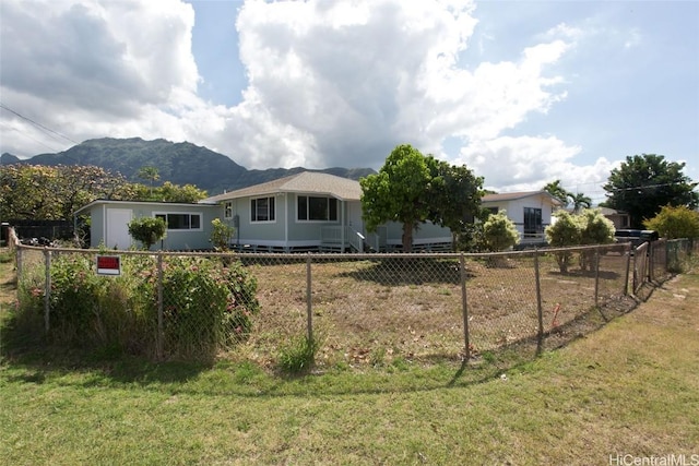 view of front of property featuring a mountain view, fence, and a front yard