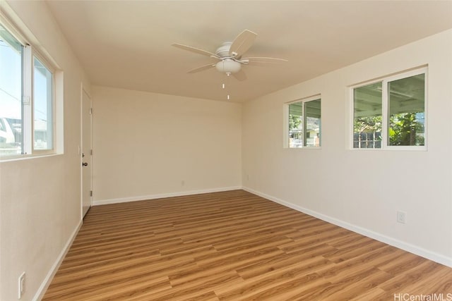 unfurnished room featuring light wood finished floors, baseboards, plenty of natural light, and ceiling fan
