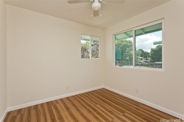 spare room featuring a ceiling fan, baseboards, and wood finished floors