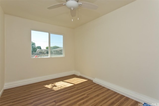spare room featuring a ceiling fan, baseboards, and wood finished floors