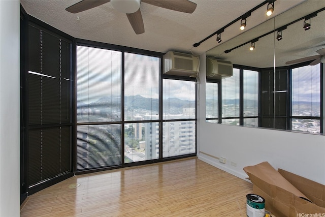 60 N Beretania St Unit 3405, Honolulu, HI 96817 - empty room featuring a textured ceiling, a ceiling fan, wood finished floors, baseboards, and floor to ceiling windows