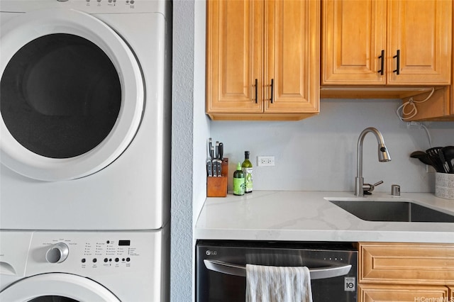 clothes washing area featuring stacked washer and clothes dryer, a sink, and laundry area