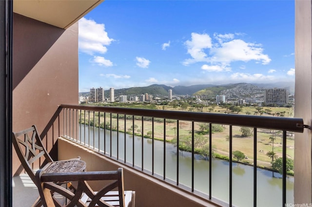 balcony featuring a water and mountain view and a view of city