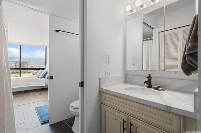 ensuite bathroom with ensuite bath, toilet, vanity, and tile patterned floors