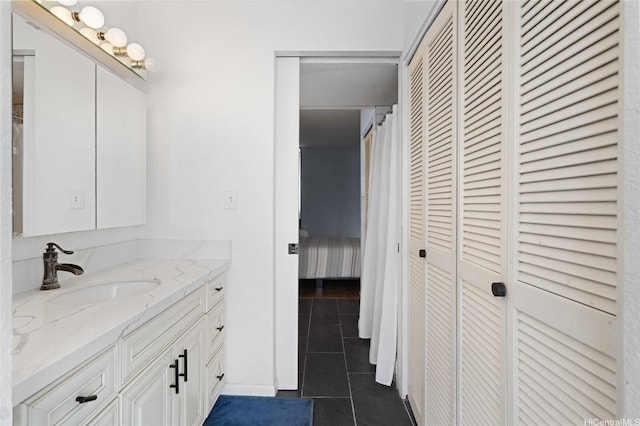bathroom with a closet, tile patterned floors, and vanity