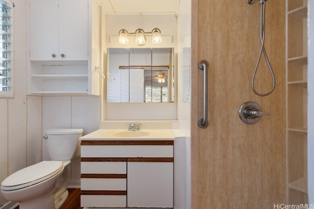 bathroom featuring toilet, vanity, and walk in shower