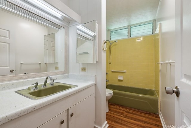 bathroom with toilet, wood finished floors, bathtub / shower combination, and vanity