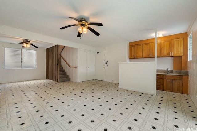 interior space featuring a wealth of natural light, stairway, a ceiling fan, and light floors