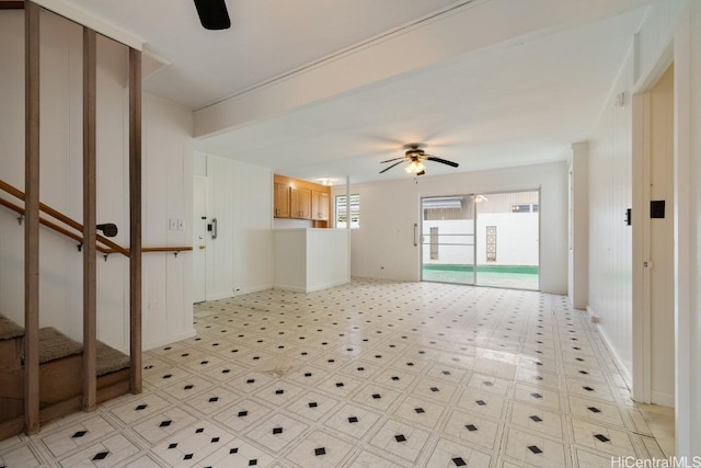 unfurnished living room with light floors, stairway, and a ceiling fan