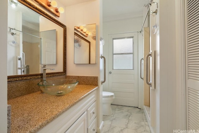 bathroom featuring a closet, toilet, vanity, a shower stall, and marble finish floor