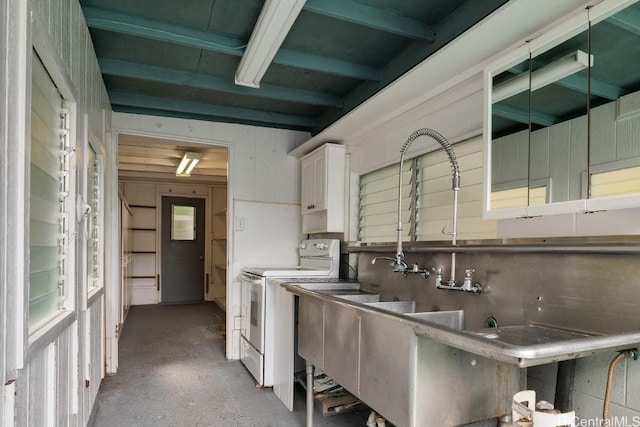 kitchen featuring white electric range, white cabinets, and concrete floors