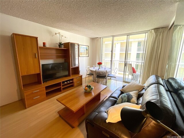 2452 Tusitala St Unit 703, Honolulu, HI 96815 - living area with light wood finished floors, a textured ceiling, and expansive windows
