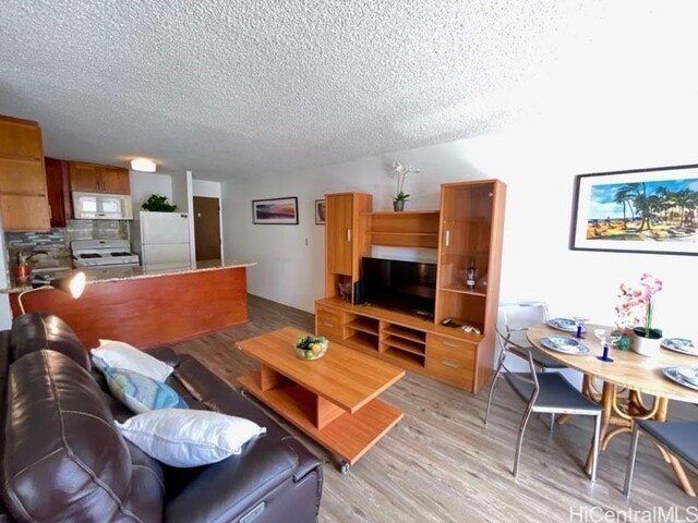 2452 Tusitala St Unit 703, Honolulu, HI 96815 - living room featuring a textured ceiling and light wood-style floors