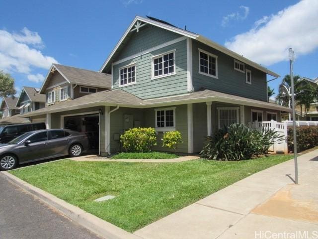 farmhouse featuring a garage and a front lawn