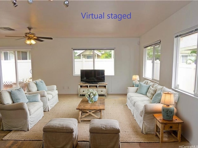living room with visible vents, a wealth of natural light, and ceiling fan