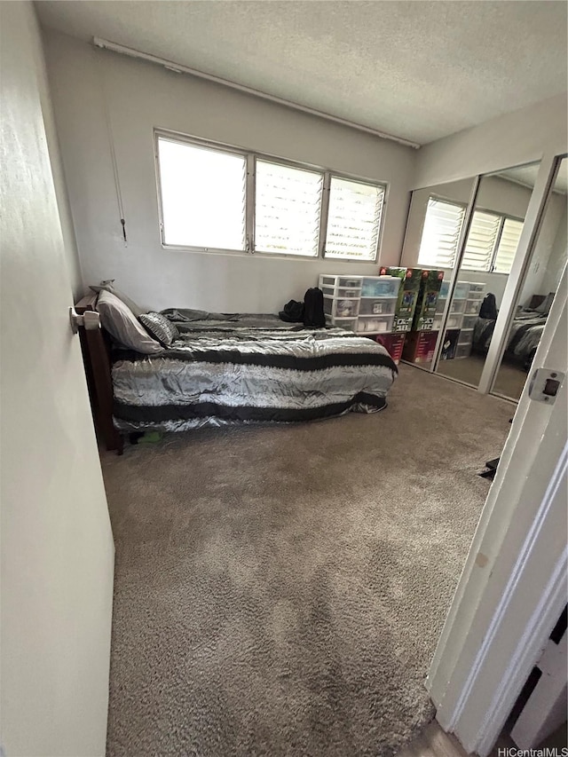 bedroom with carpet and a textured ceiling