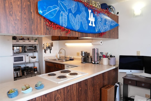 kitchen with cooktop, a toaster, light countertops, a sink, and white microwave