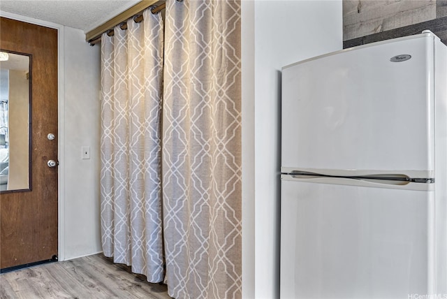 interior space featuring a textured ceiling and wood finished floors