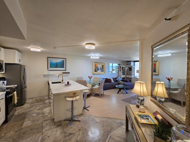 60 N Beretania St Unit 3209, Honolulu, HI 96817 - kitchen with appliances with stainless steel finishes, a breakfast bar, white cabinetry, light countertops, and open floor plan