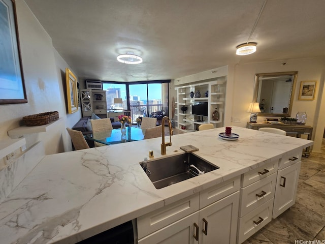 60 N Beretania St Unit 3209, Honolulu, HI 96817 - kitchen featuring open floor plan, white cabinetry, light stone countertops, and expansive windows