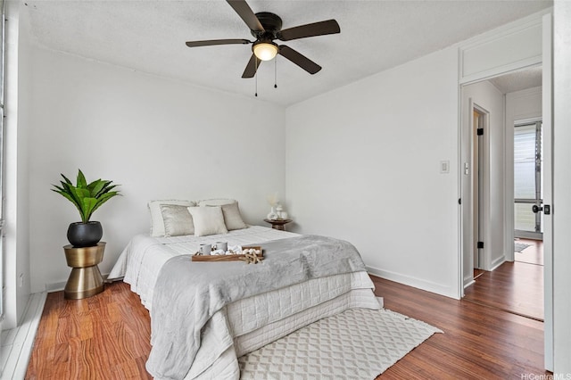 bedroom with baseboards, wood finished floors, and ceiling fan