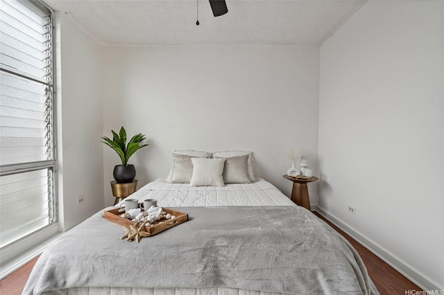 bedroom with baseboards, a ceiling fan, and wood finished floors